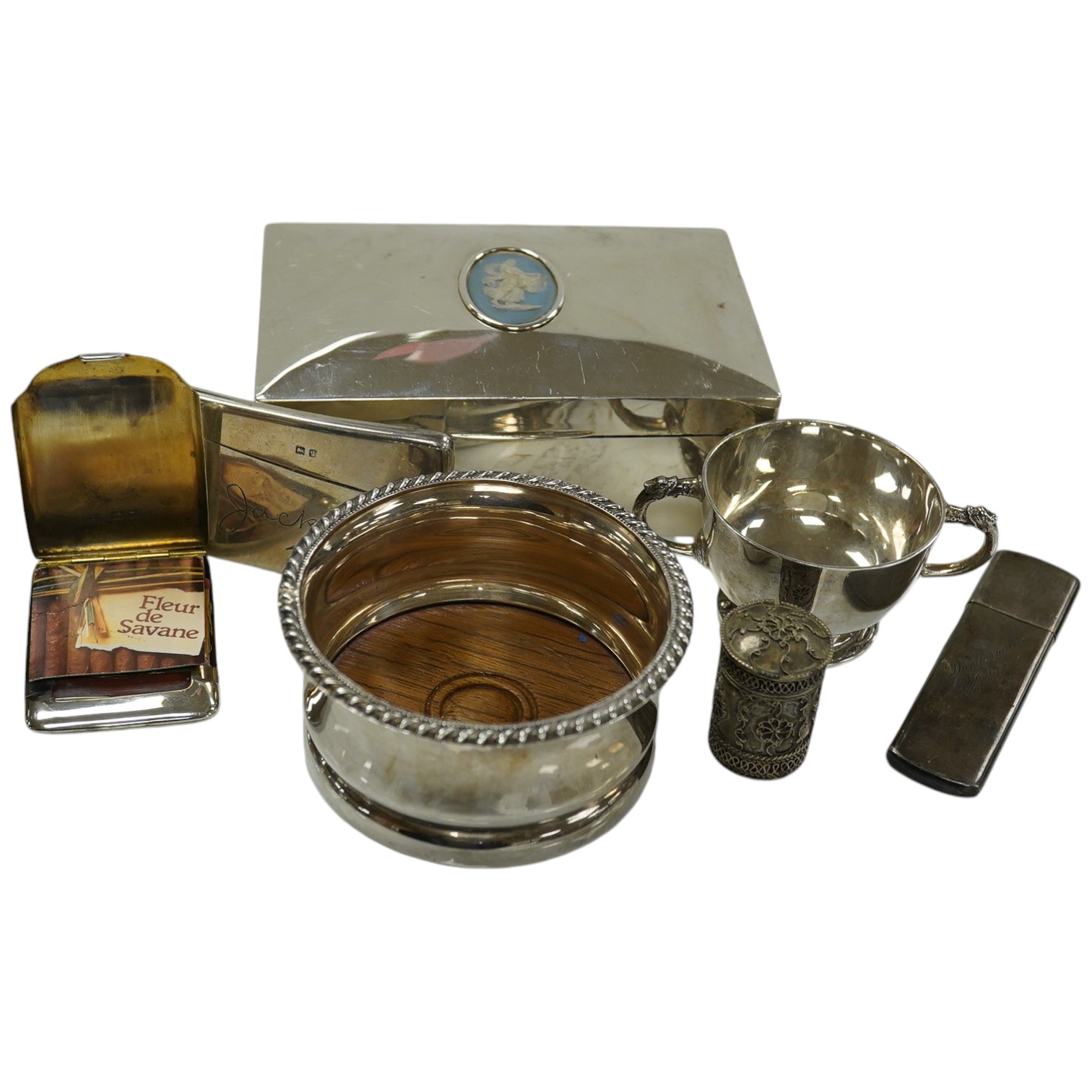 Sundry silver including a cigarette box (marks rubbed), 13.2cm, cased tea strainer, mounted wine coaster, small cup, match sleeve, card case, small case and 925 cylindrical box and cover. Condition - poor to fair to good